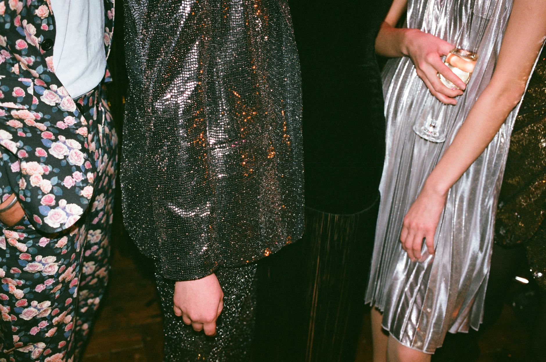 Detail shot of an elegant evening outfit with a small structured handbag held by hand