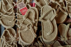 The Fisherman Sandal Is Quietly Edging Out the Strappy Heel Close-up of brown leather fisherman sandals on a wooden surface
