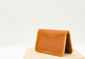 A luxury leather bifold wallet placed on a clean surface, showing fine leather texture and craftsmanship