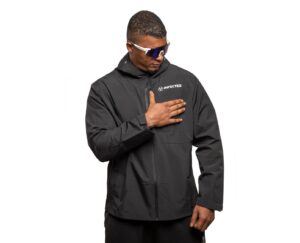 A structured minimalist jacket laid flat on a neutral surface, representing modern outerwear design