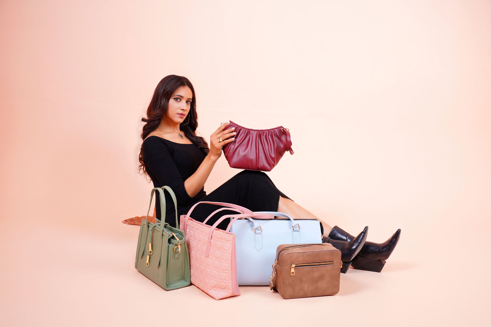 Structured crescent-shaped leather top handle bag in camel tan colorway on neutral background