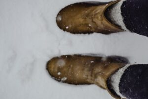 Acne Studios’ Shearling Boot Is Quietly Edging Out the Chelsea Close-up of shearling-trimmed ankle boots on a wooden floor