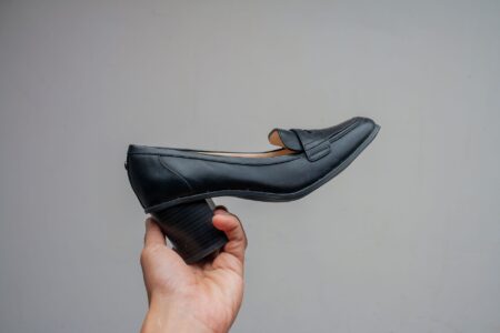 The Woven Leather Loafer Is Quietly Edging Out the Penny Loafer Close-up of woven leather loafers on a wooden surface showing detailed interlaced construction