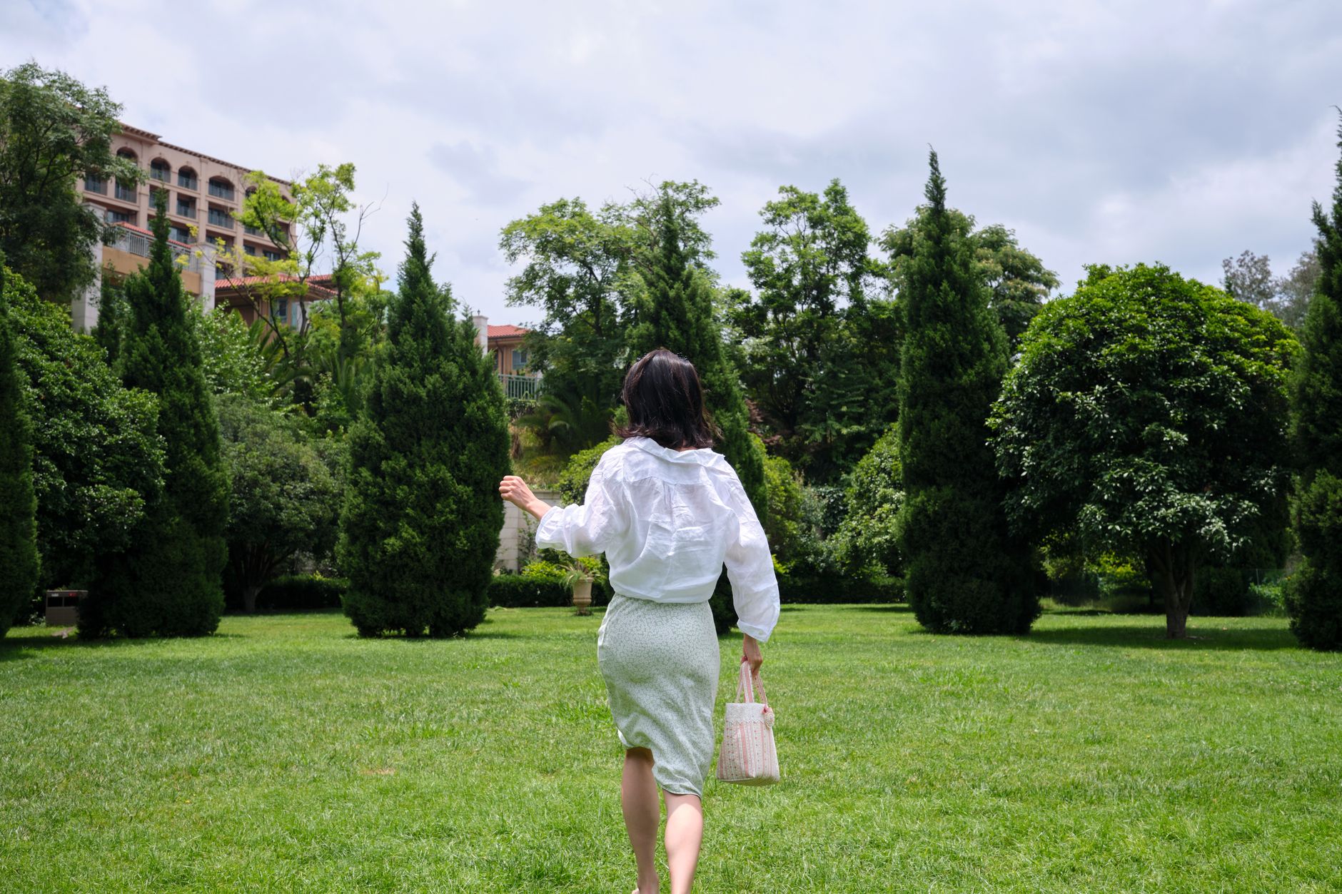 A white broderie anglaise midi skirt with delicate eyelet embroidery detailing, laid flat or worn casually outdoors