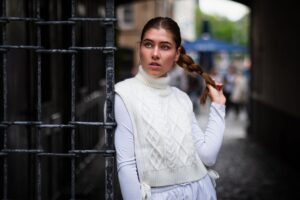 The Ribbed Knit Vest Is Quietly Edging Out the Fitted Turtleneck A ribbed knit vest styled over a white collared shirt, worn as a layering piece