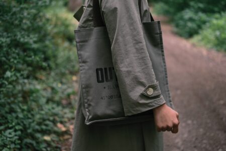 The Celine Triomphe Canvas Is Quietly Edging Out the Monogram Tote Close-up of a structured canvas tote bag with subtle logo pattern on a neutral background