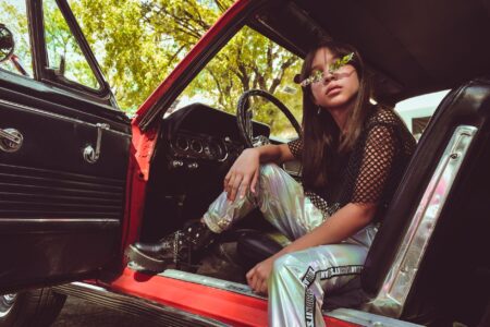 The Mesh Top Is Quietly Edging Out the Fitted Bodysuit Woman wearing a black mesh top styled with high-waisted trousers in a street fashion setting