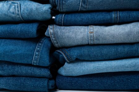 Acne Studios’ Distressed Denim Is Quietly Edging Out the Straight Leg Close-up of distressed denim jeans with raw hem detailing on a model