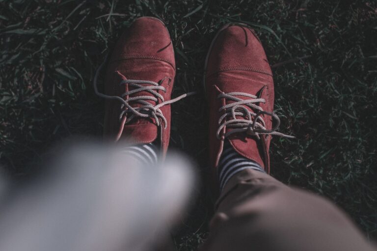 Close-up of a pair of minimalist suede slip-on shoes on a neutral background