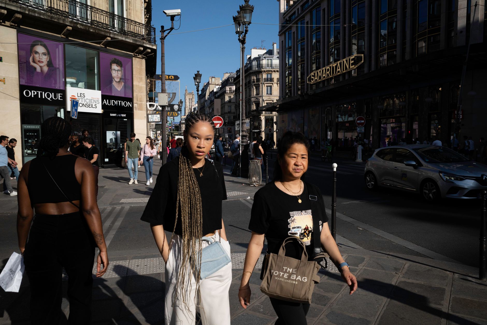 Woman carrying structured leather bag while walking on a European city street in tailored clothing