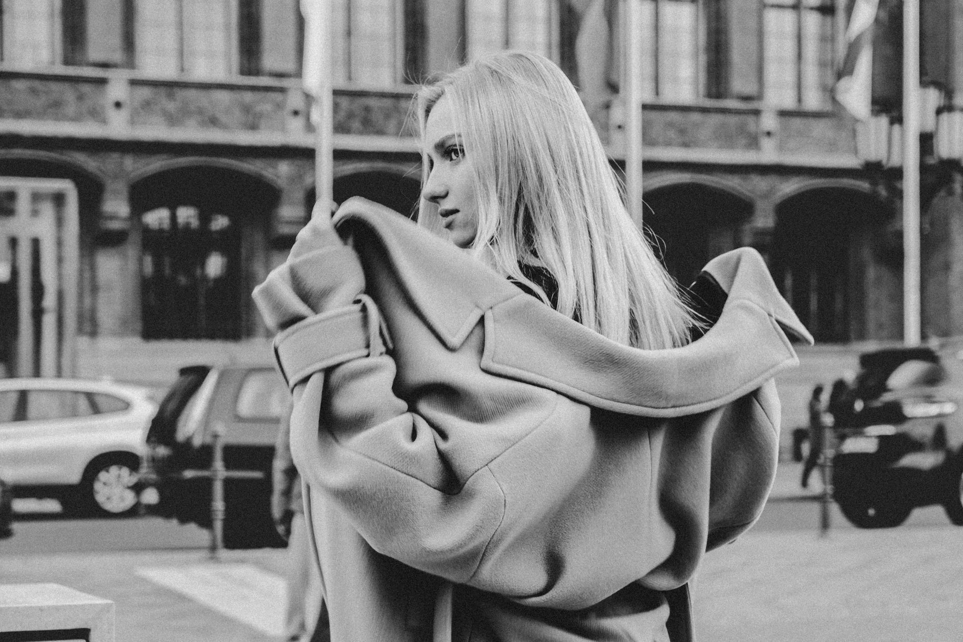 A woman wearing a wool scarf wrapped around her neck over a tailored winter coat
