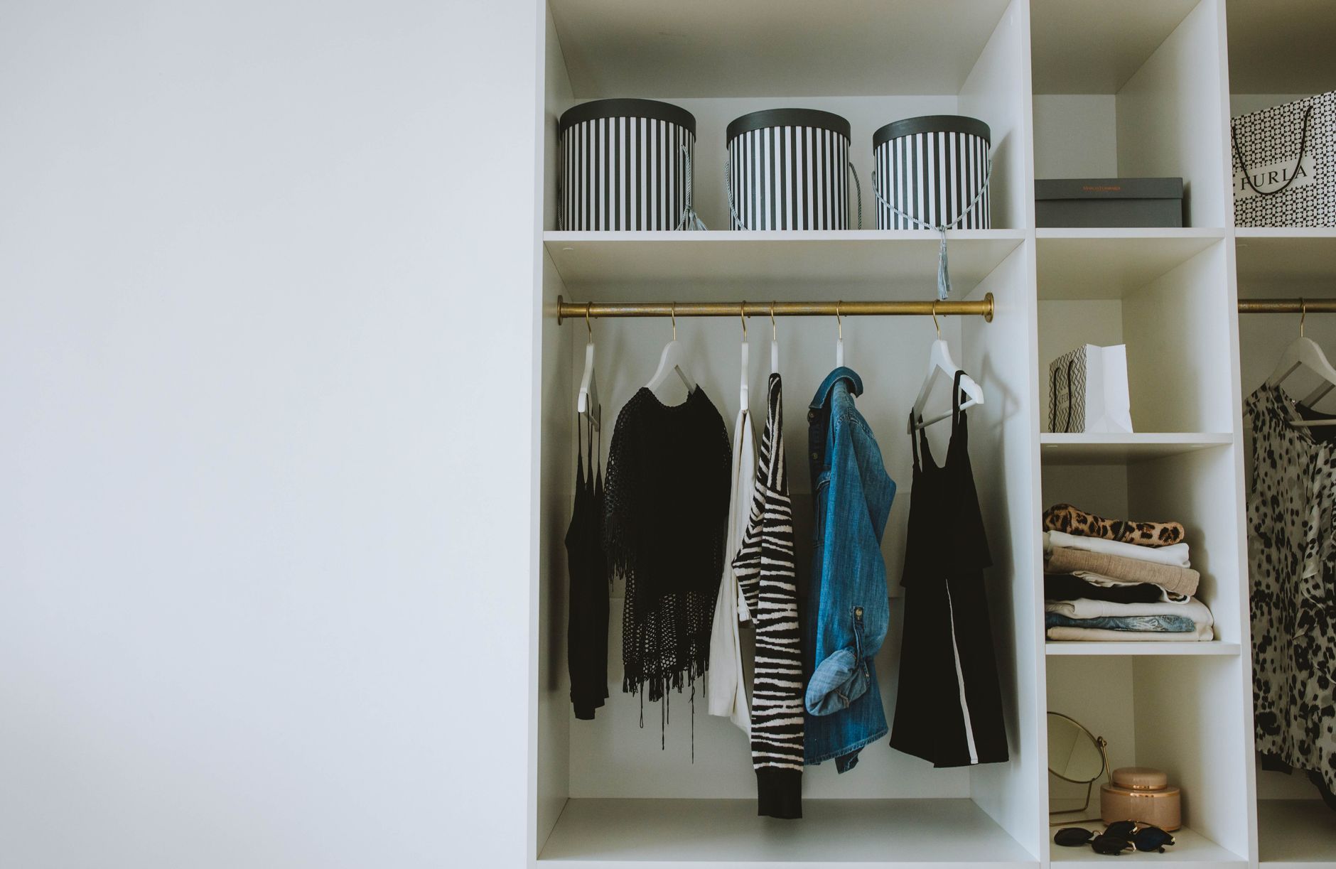 A minimalist wardrobe flat lay featuring neutral toned knitwear and layering pieces