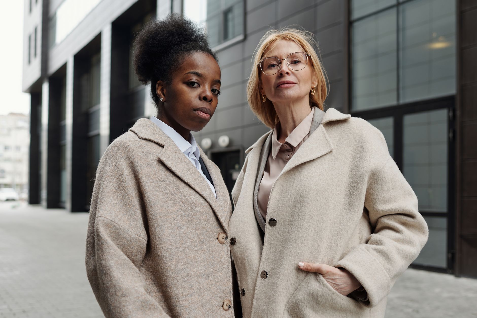 A woman wearing a structured straight coat walking on a city street