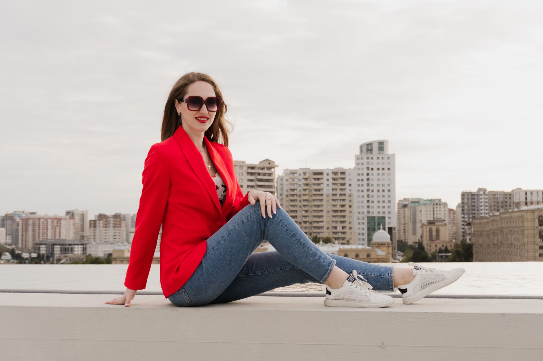 A woman wearing a tailored blazer cinched with a slim leather belt over wide-leg trousers