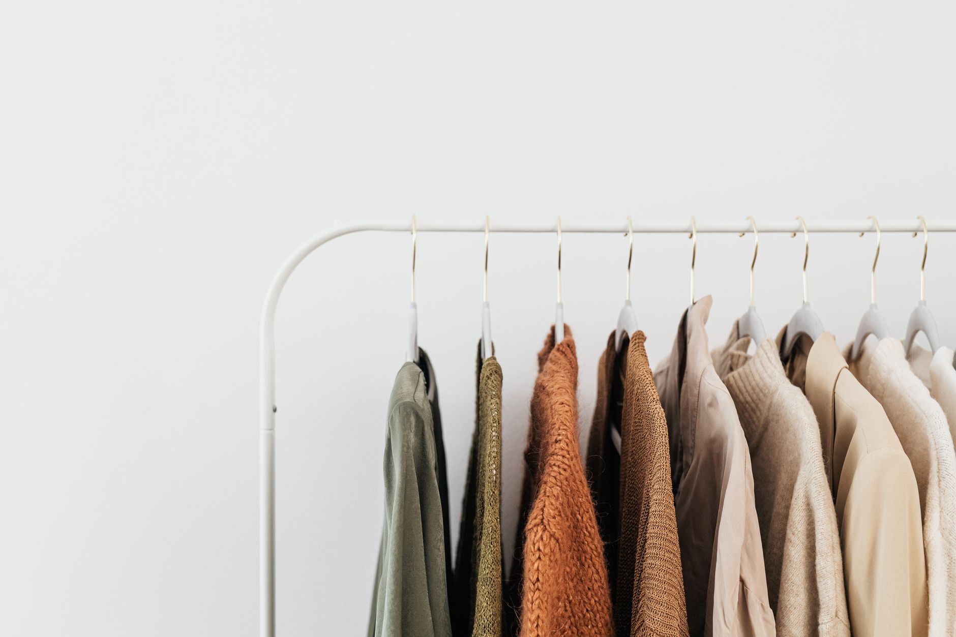 Minimalist wardrobe with neutral-toned clothing hanging in an organized closet