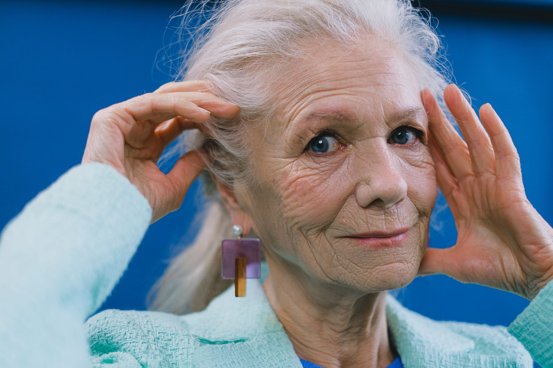 Woman wearing long drop earrings styled with minimal clothing