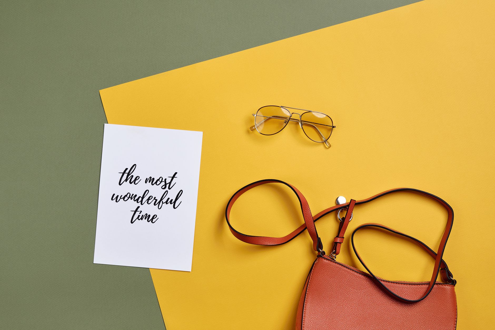 Clean minimal leather handbag photographed from above on a light surface