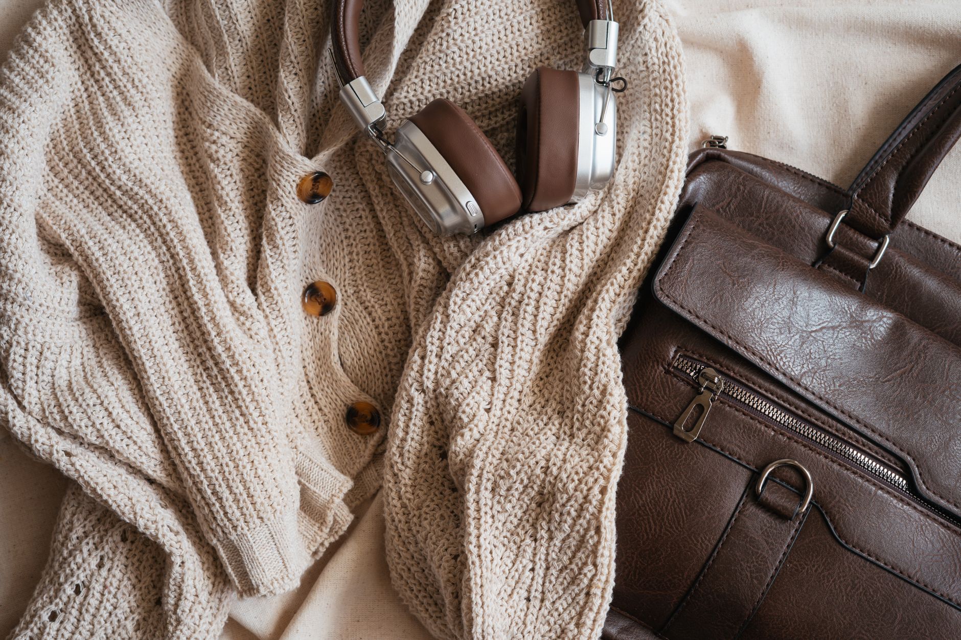 Close-up of fine knit accessories in neutral tones arranged on a minimal background