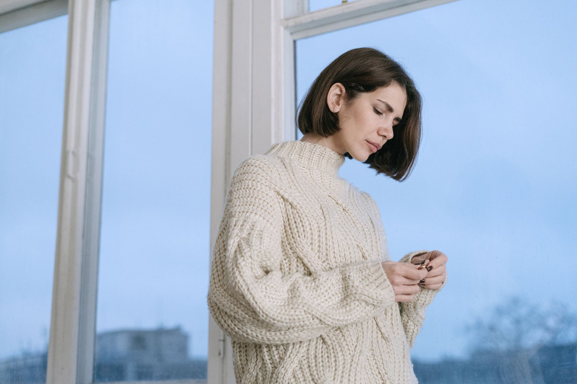 A woman wearing a relaxed fit knit cardigan styled over a simple outfit in neutral colors