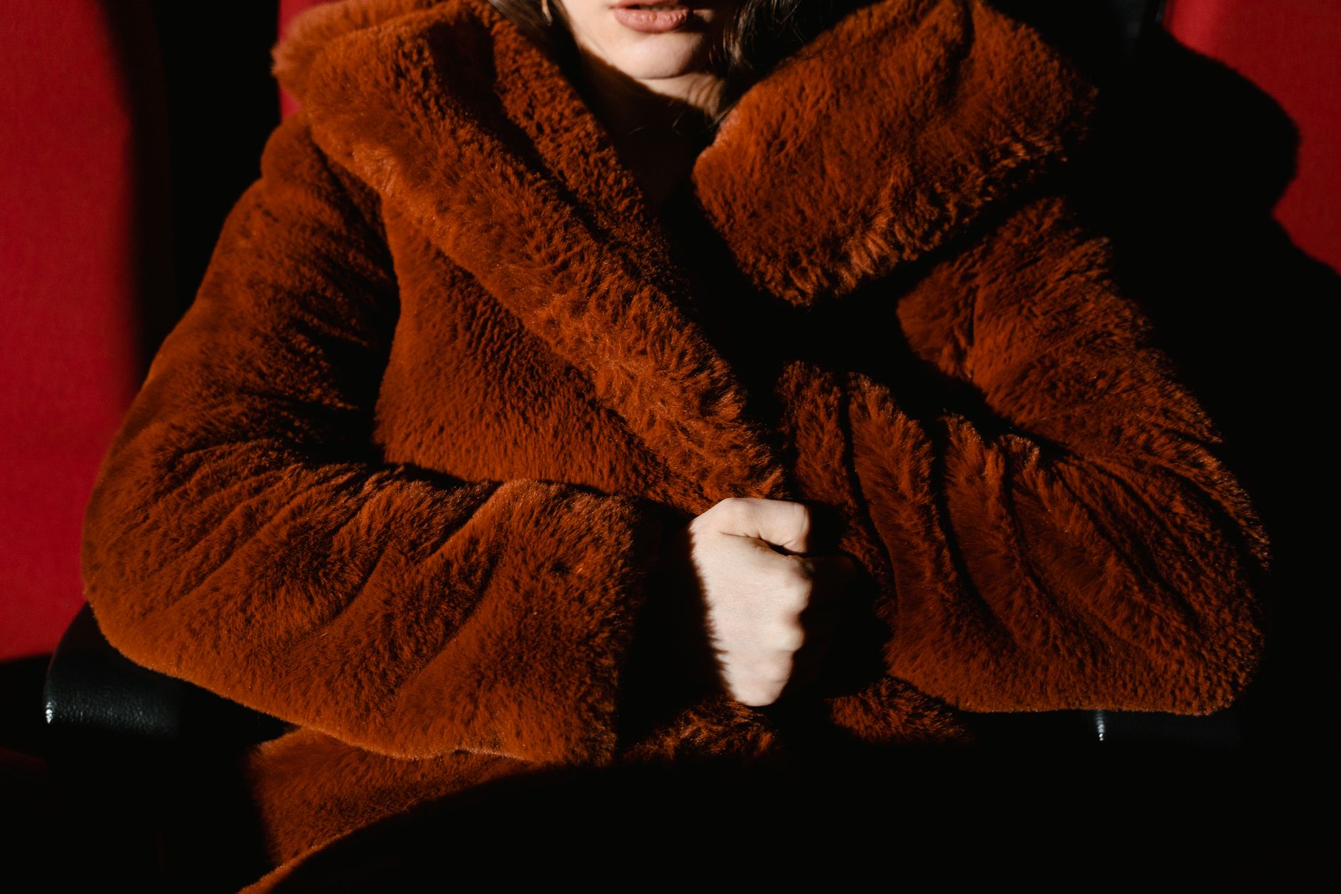 Close-up detail of a shearling coat collar and belt construction