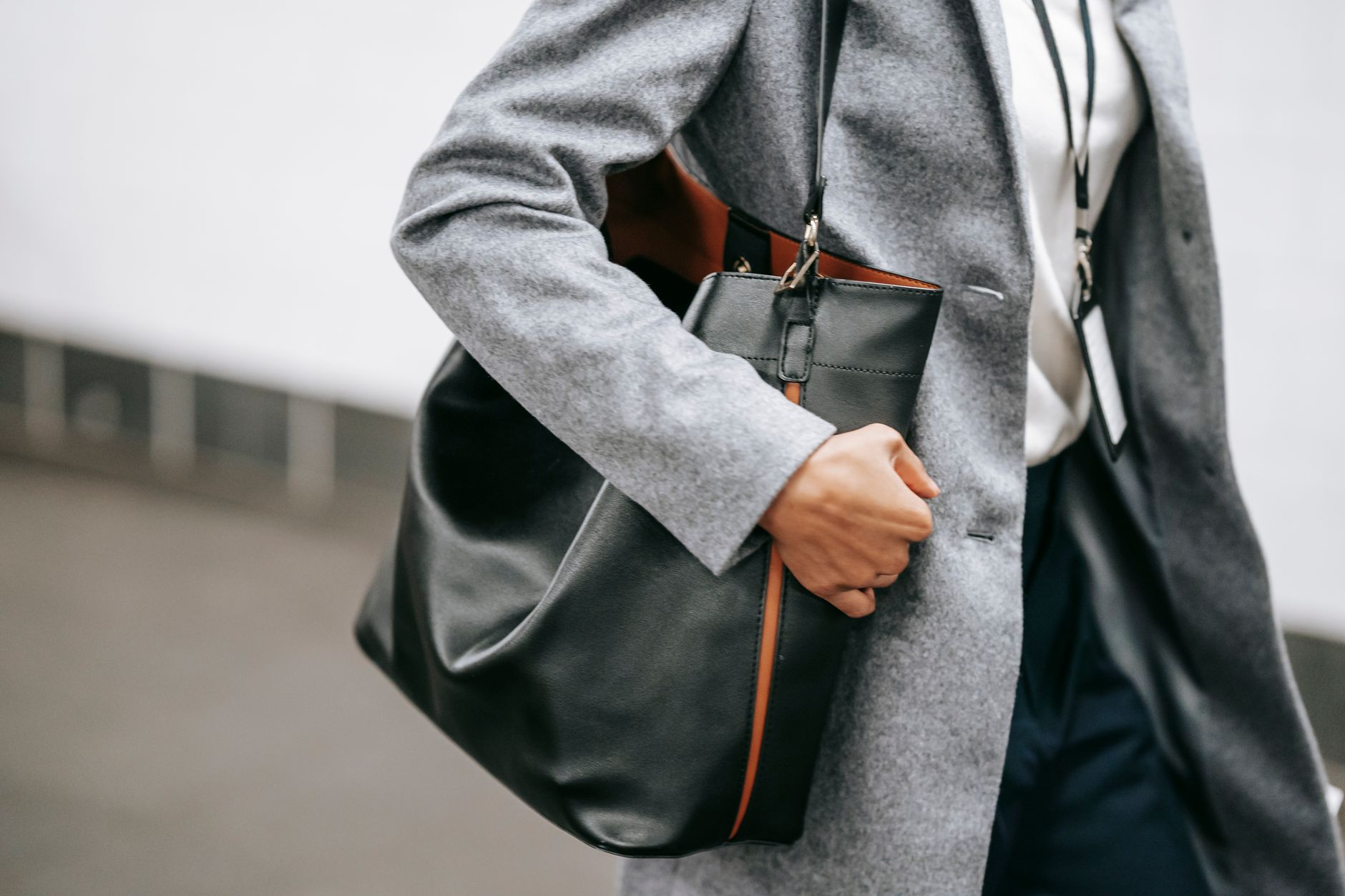 A well-dressed woman carrying a structured leather handbag, embodying understated luxury fashion