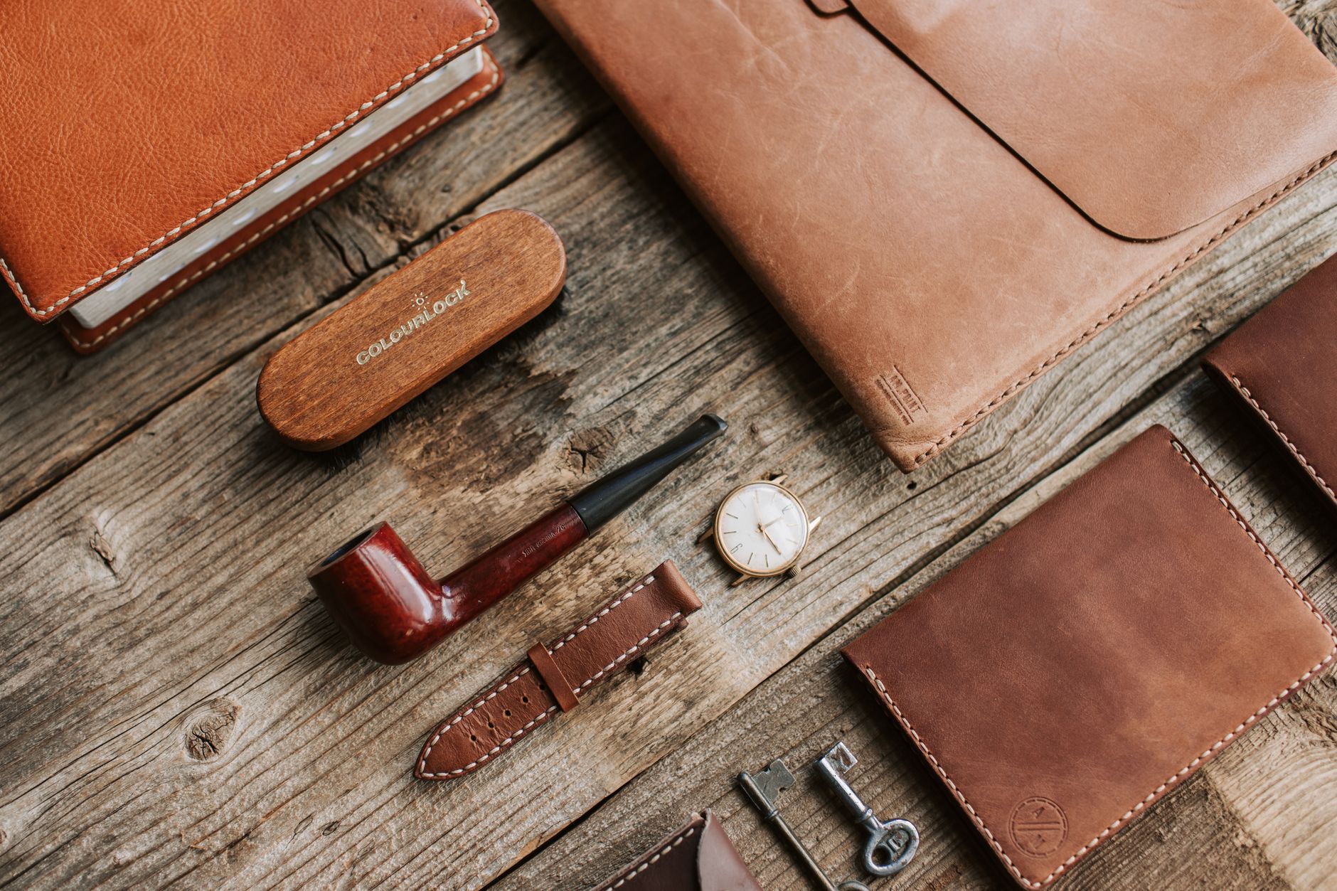 A collection of slim leather belts with understated metal hardware in various neutral tones