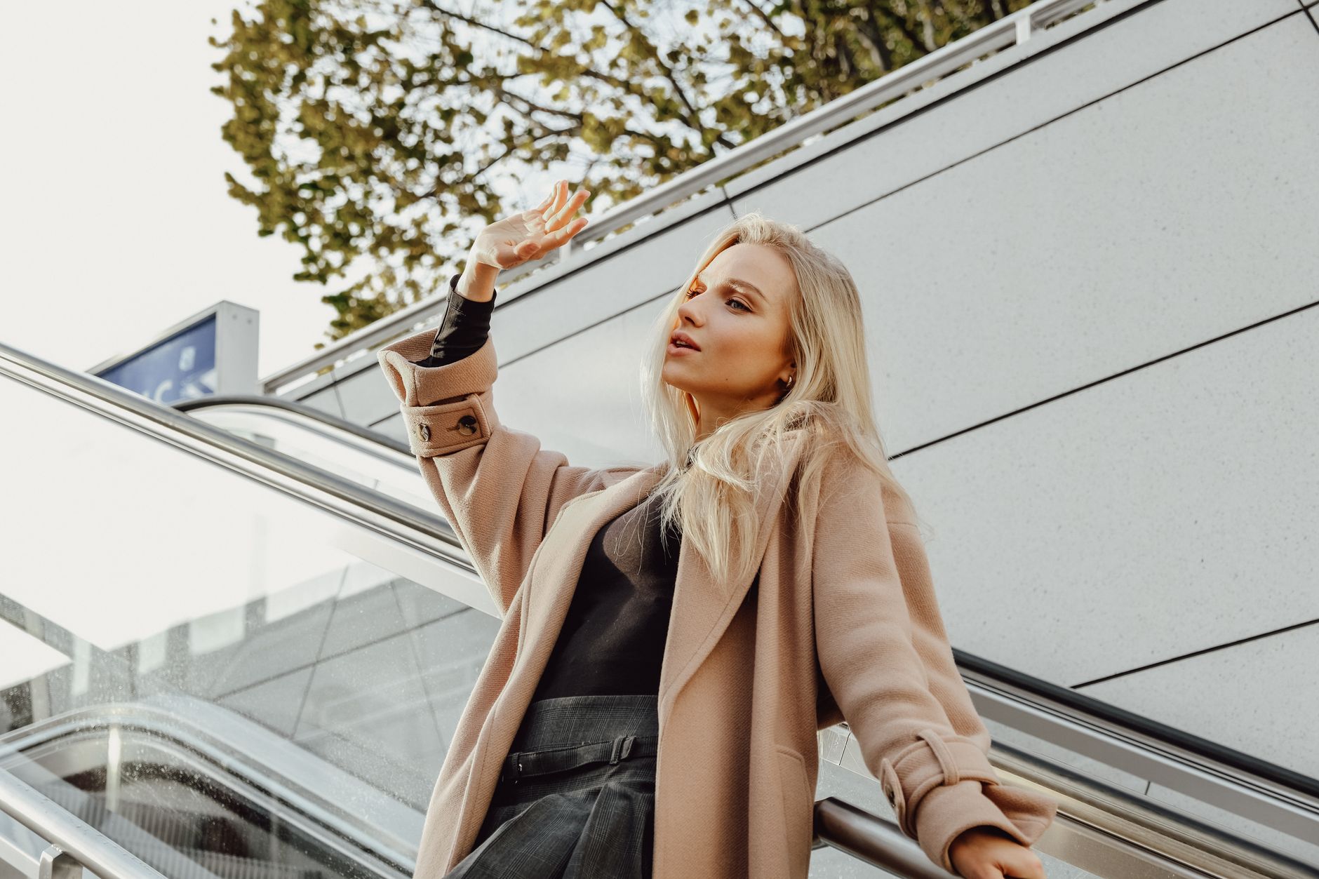 Classic belted trench coat on a model, contrasting with the looser shirt jacket trend