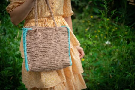 The Crochet Tote Is Quietly Edging Out the Woven Bucket Bag A handmade crochet tote bag in natural cotton yarn displayed against a light background