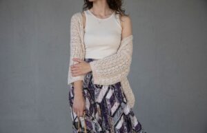 The Longline Cardigan Is Quietly Edging Out the Structured Coat Woman wearing an oversized longline cardigan as an outerwear layer over tailored trousers