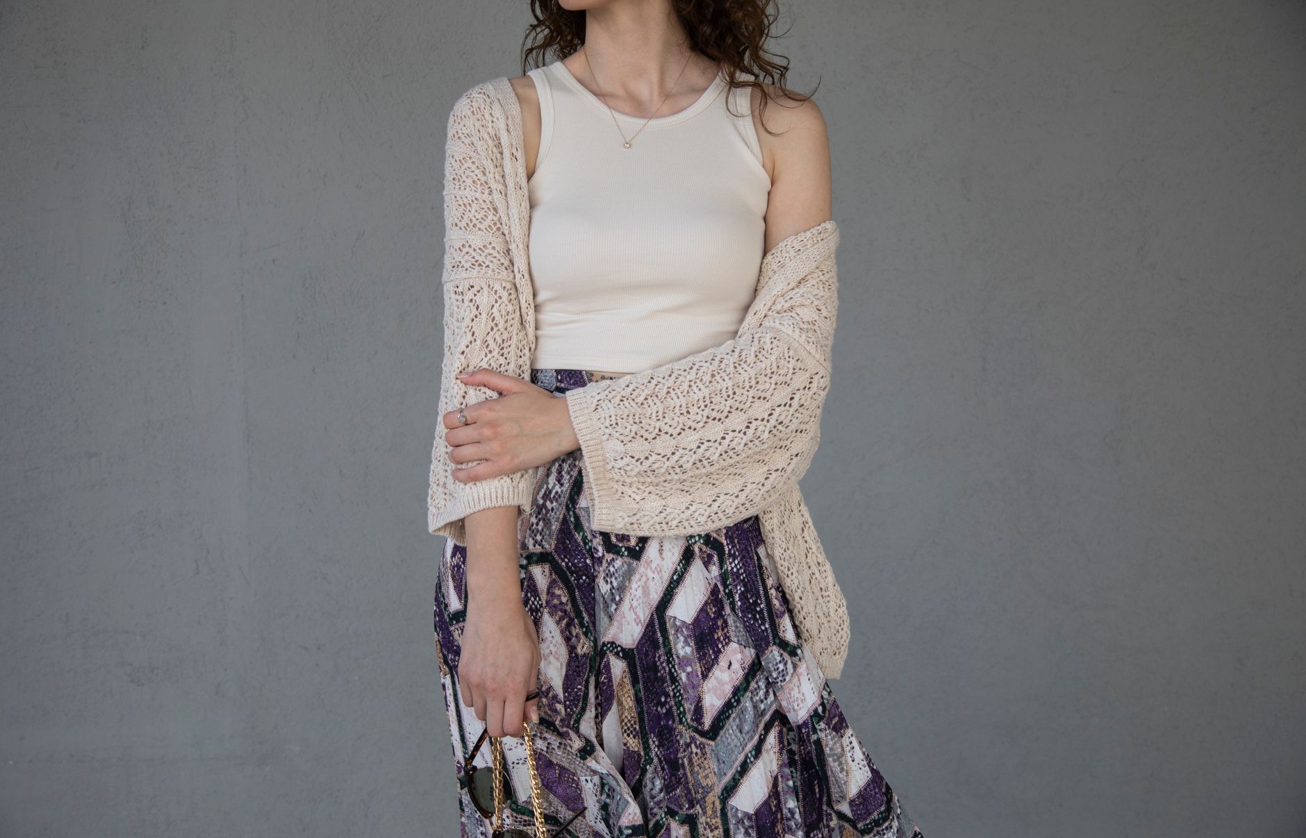 Woman wearing an oversized longline cardigan as an outerwear layer over tailored trousers