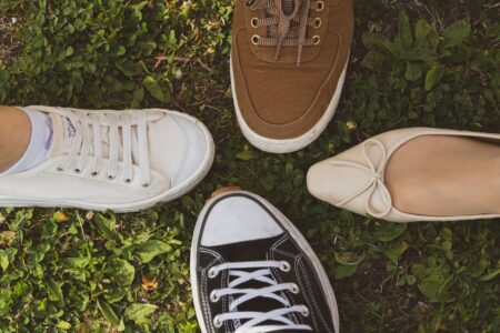 The Knit Ballet Flat Is Quietly Edging Out the Leather Loafer Close-up of knit ballet flats on a wooden floor beside a leather loafer