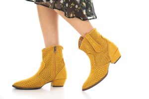 The Kitten Heel Boot Is Quietly Edging Out the Block-Heel Ankle Boot Close-up of kitten heel ankle boots styled with tailored trousers on a city street
