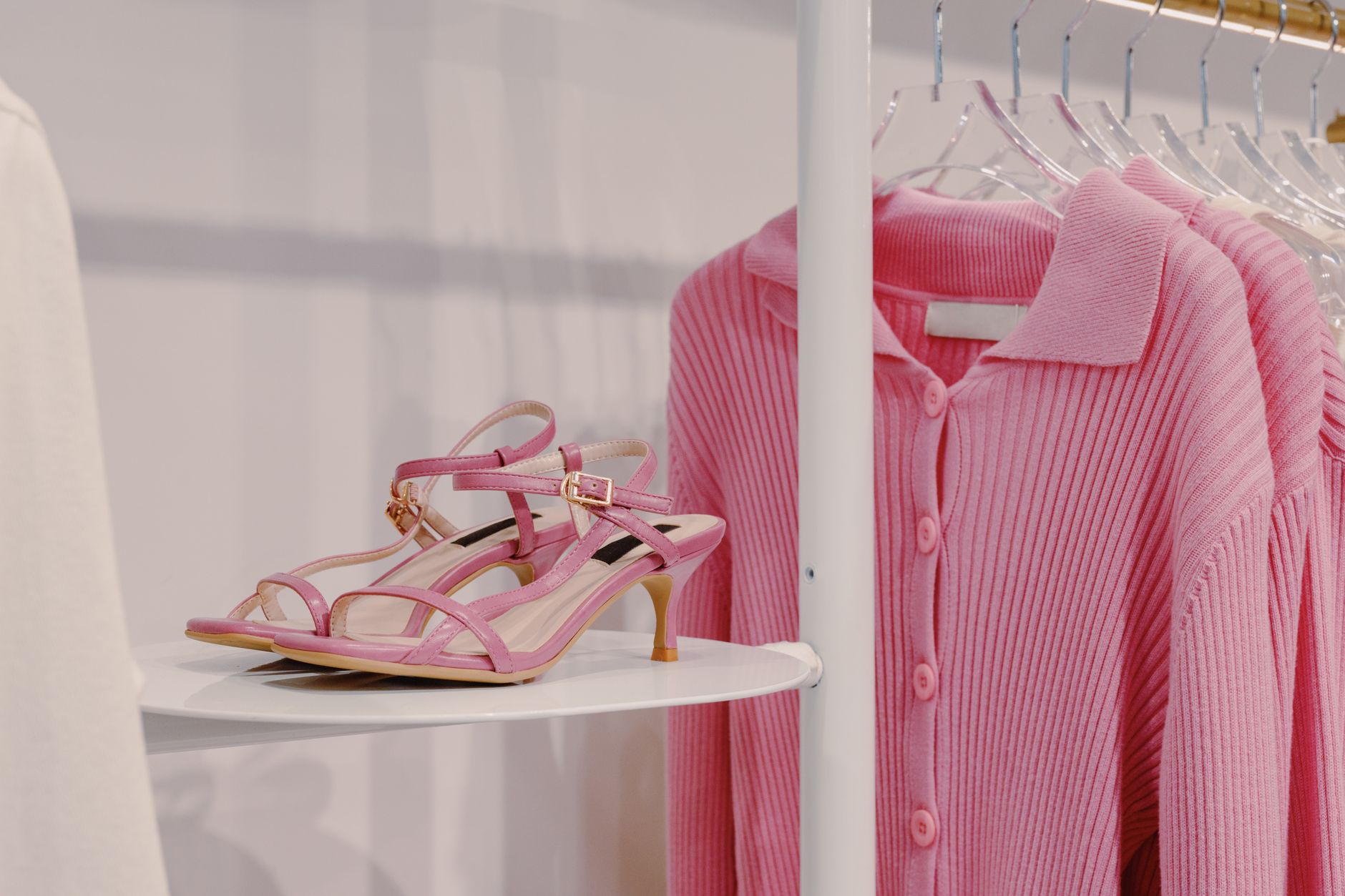 A row of women's heels displayed on a shoe rack, including slingback and pump styles
