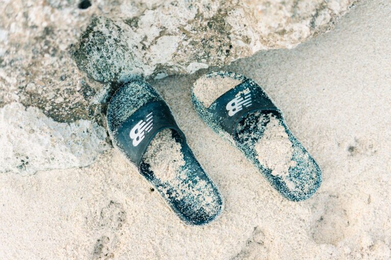 The Slide Sandal Is Quietly Edging Out the Fisherman Sandal A pair of minimalist leather slide sandals on a neutral background