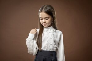 The Broderie Anglaise Blouse Is Quietly Edging Out the Prairie Dress A white broderie anglaise blouse with delicate eyelet embroidery detail laid flat on a neutral surface