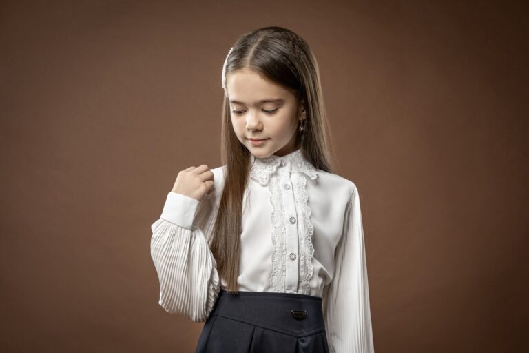 The Broderie Anglaise Blouse Is Quietly Edging Out the Prairie Dress A white broderie anglaise blouse with delicate eyelet embroidery detail laid flat on a neutral surface