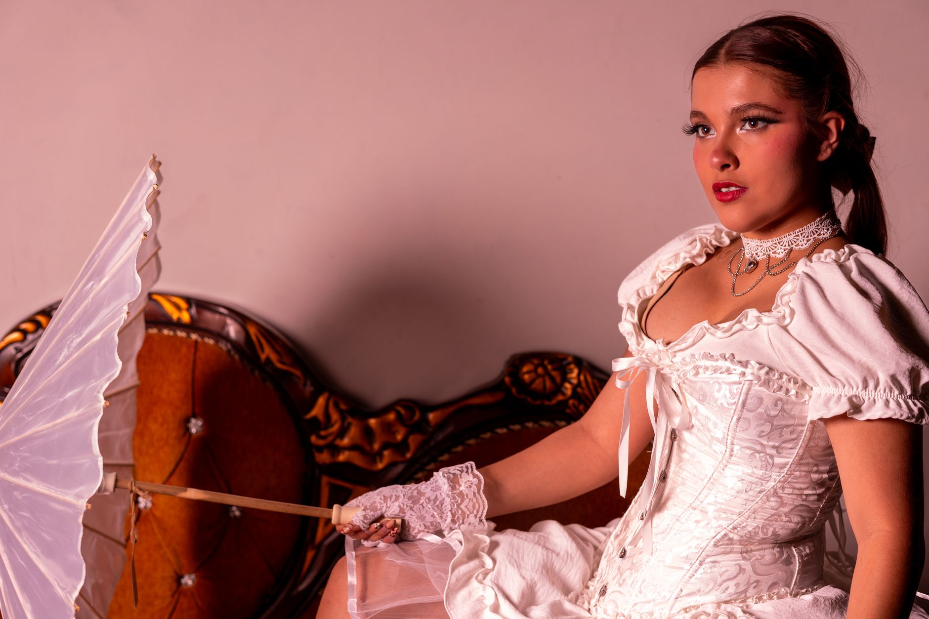 White broderie anglaise corset top laid flat on a neutral background showing eyelet embroidery detail