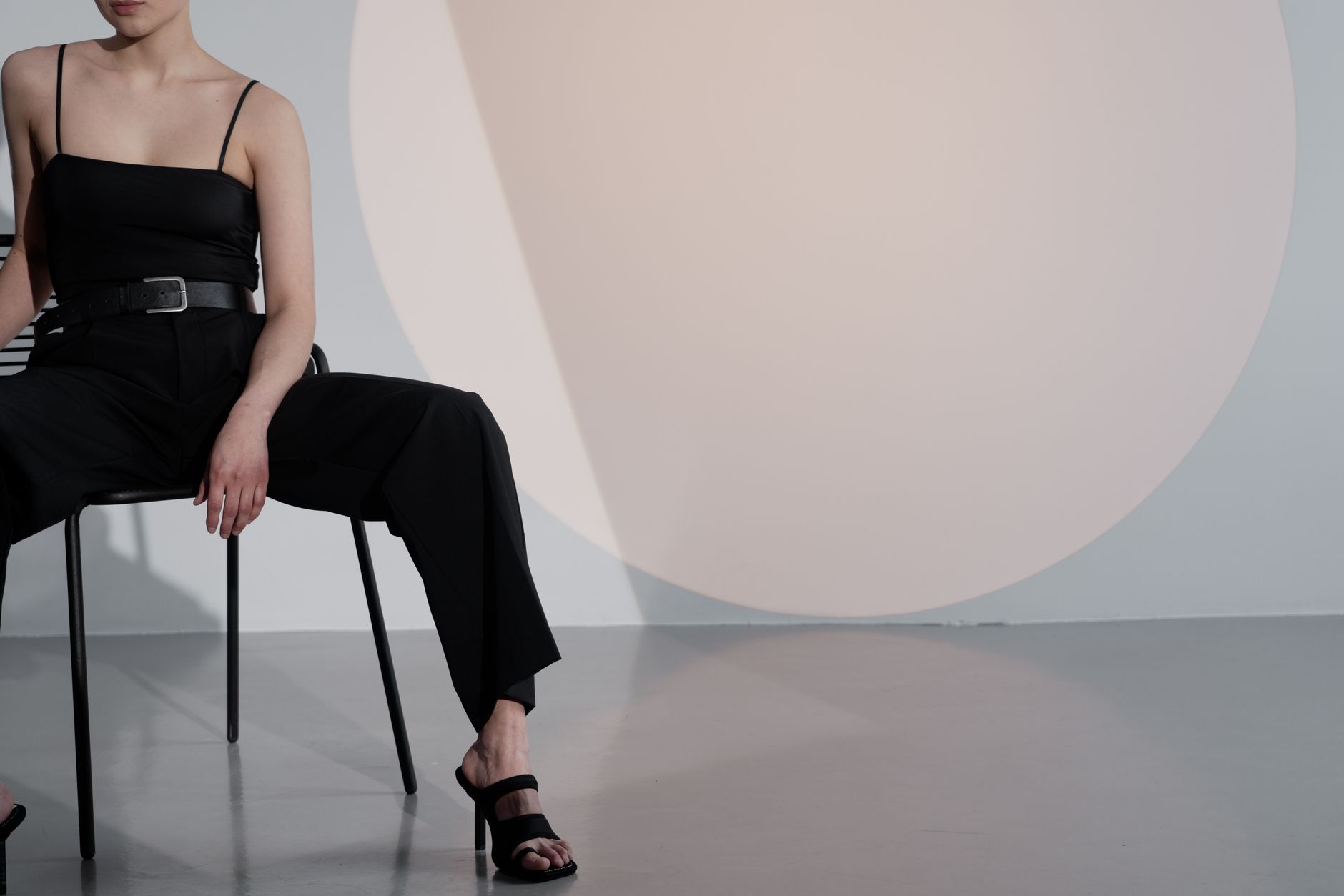 A clean, minimalist fashion look featuring a collarless structured jacket and tailored trousers