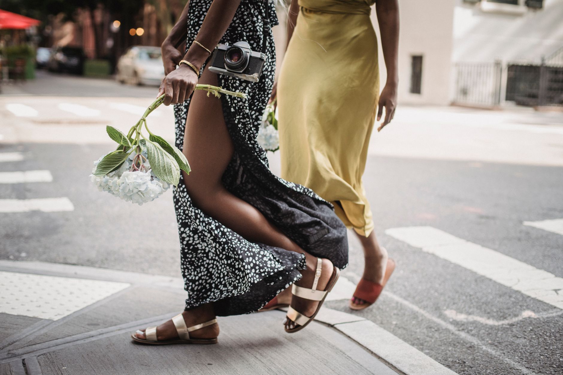 Person wearing structured sandals with relaxed wide-leg trousers on a city street