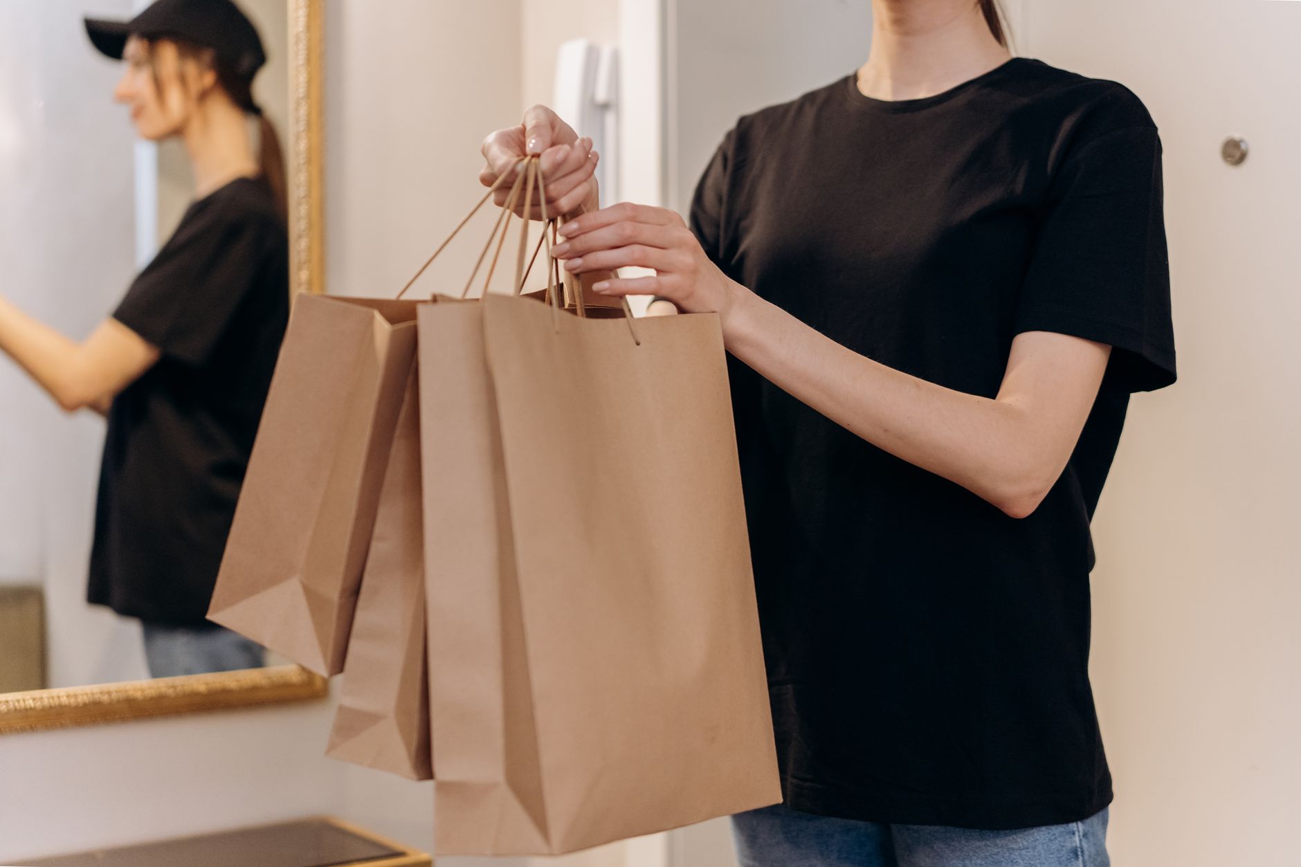 A woman carrying a soft structured handbag on her shoulder in a casual urban setting