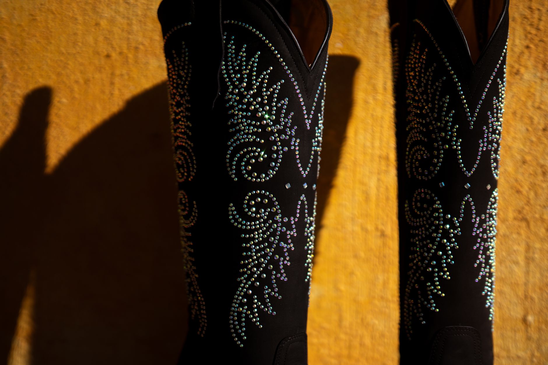 Detail shot of a pointed-toe suede boot with a slim kitten heel