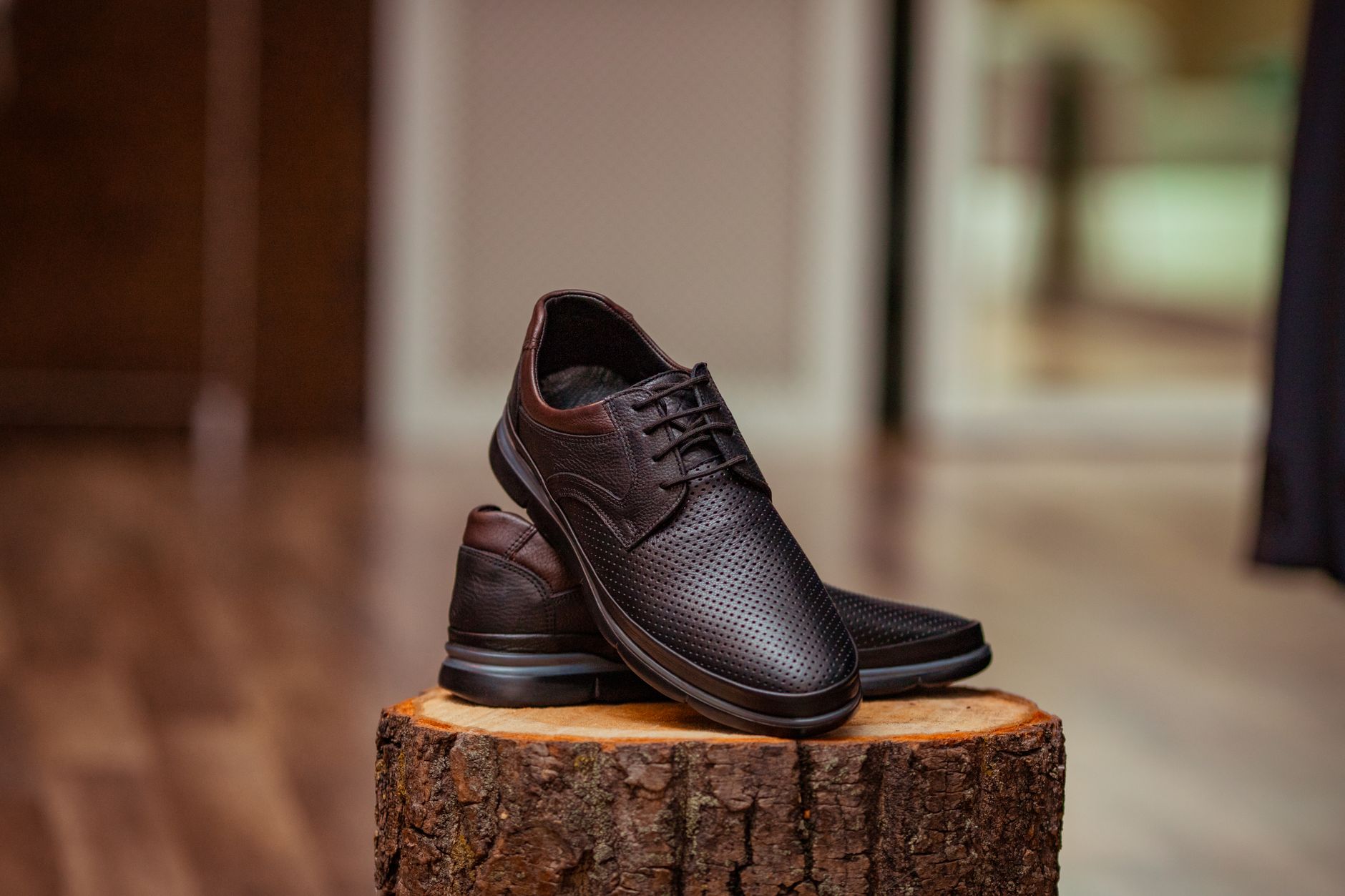 Detail shot of structured lace-up flat shoes in tan leather on a neutral background