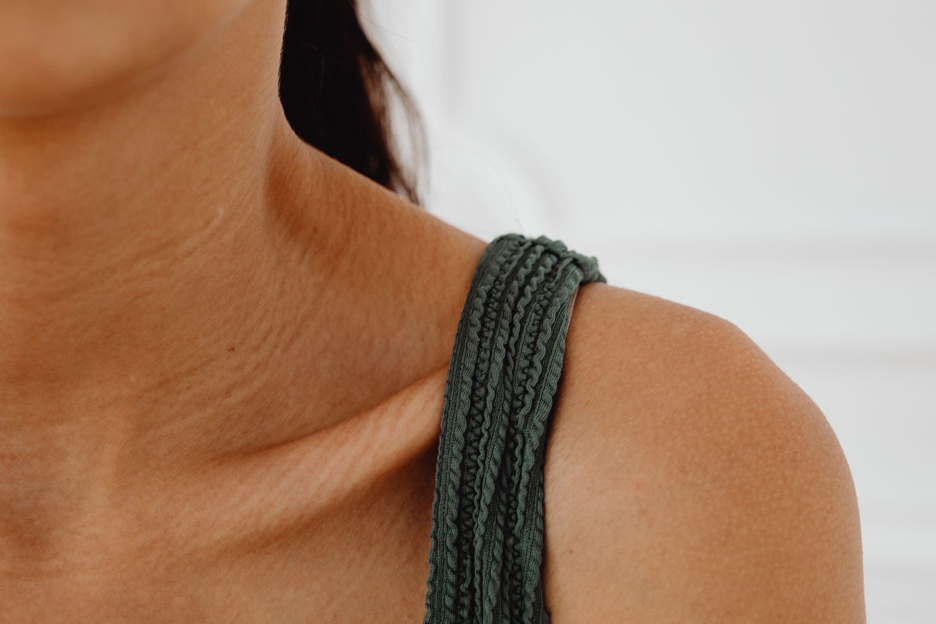Folded white cotton camisole tops displayed on a clean surface