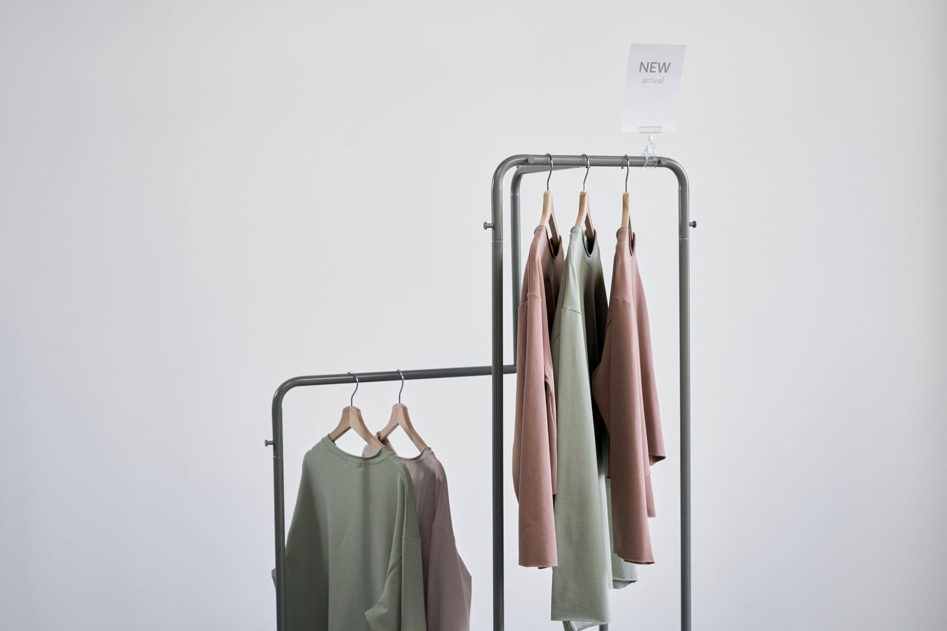 A boutique clothing rack featuring skirts in various silhouettes and neutral colors