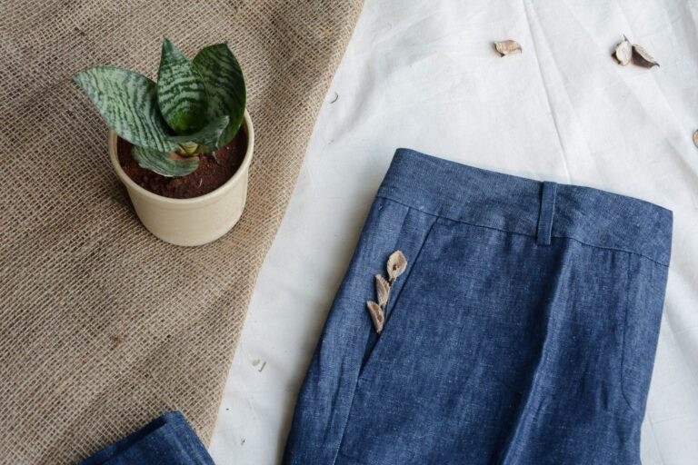 The Linen Trousers Are Quietly Edging Out the Relaxed Chino Neatly folded linen trousers in neutral tones displayed on a clothing rack