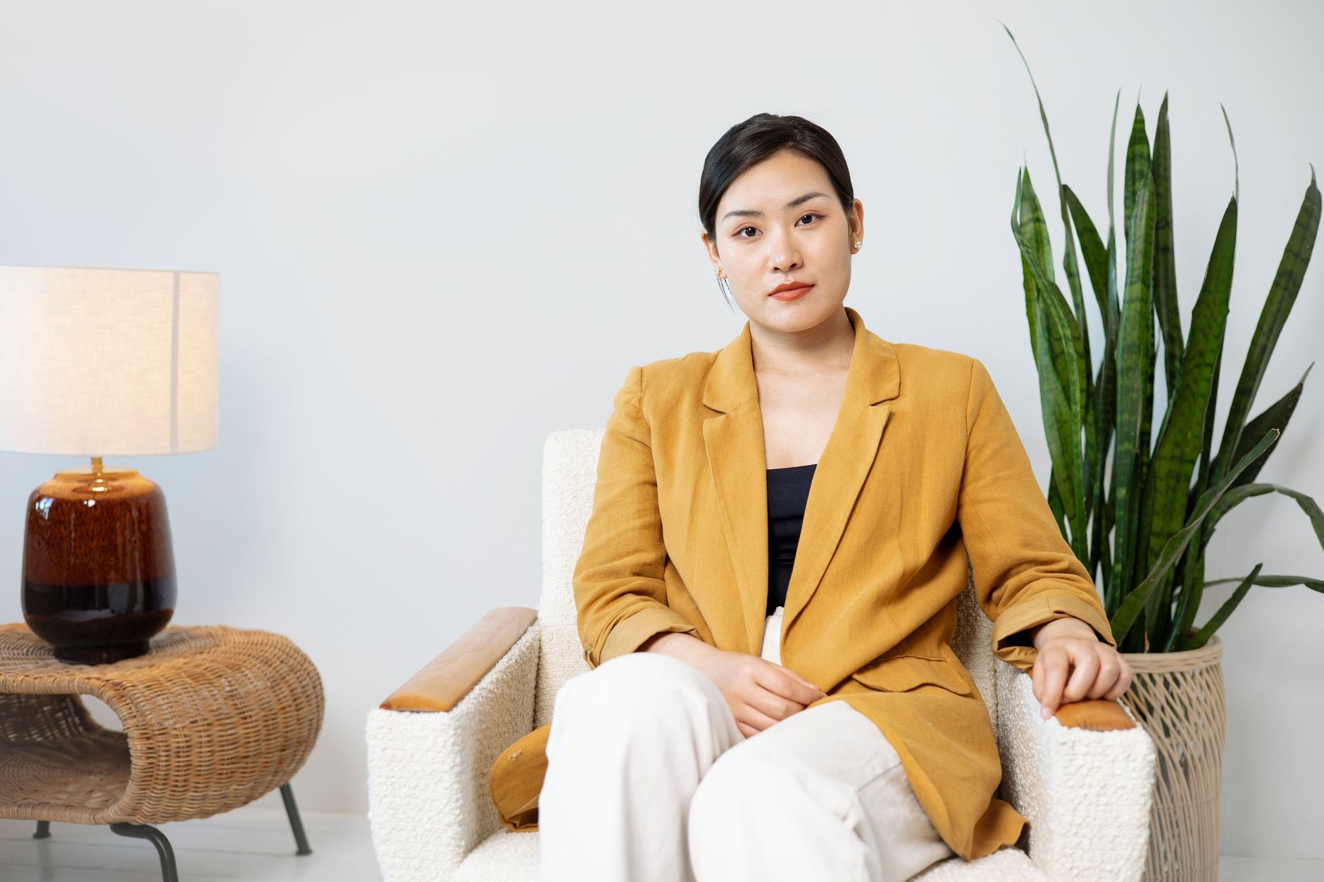 A neatly structured linen blazer in a neutral oat tone laid flat on a white surface