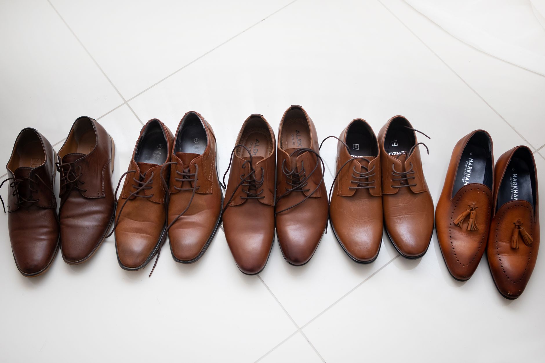 A pair of sleek pointed-toe loafers in tan leather displayed on a neutral background