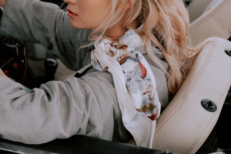 The Tube Scarf Is Quietly Edging Out the Silk Neckerchief Close-up of a person wearing a fitted tube scarf in a neutral tone with a structured coat