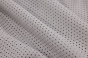 The Broderie Anglaise Trouser Is Quietly Edging Out the Linen Wide-Leg Close-up of white broderie anglaise cotton fabric showing delicate embroidered cutwork pattern