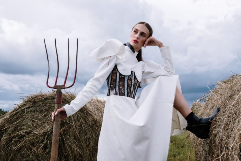 The Broderie Anglaise Corset Top Is Quietly Edging Out the Bustier Woman wearing a white structured corset top with eyelet embroidery detail
